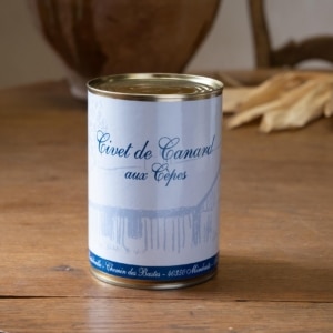 Boîte de civet de canard aux cèpes, jarre en terre cuite floue à l’arrière