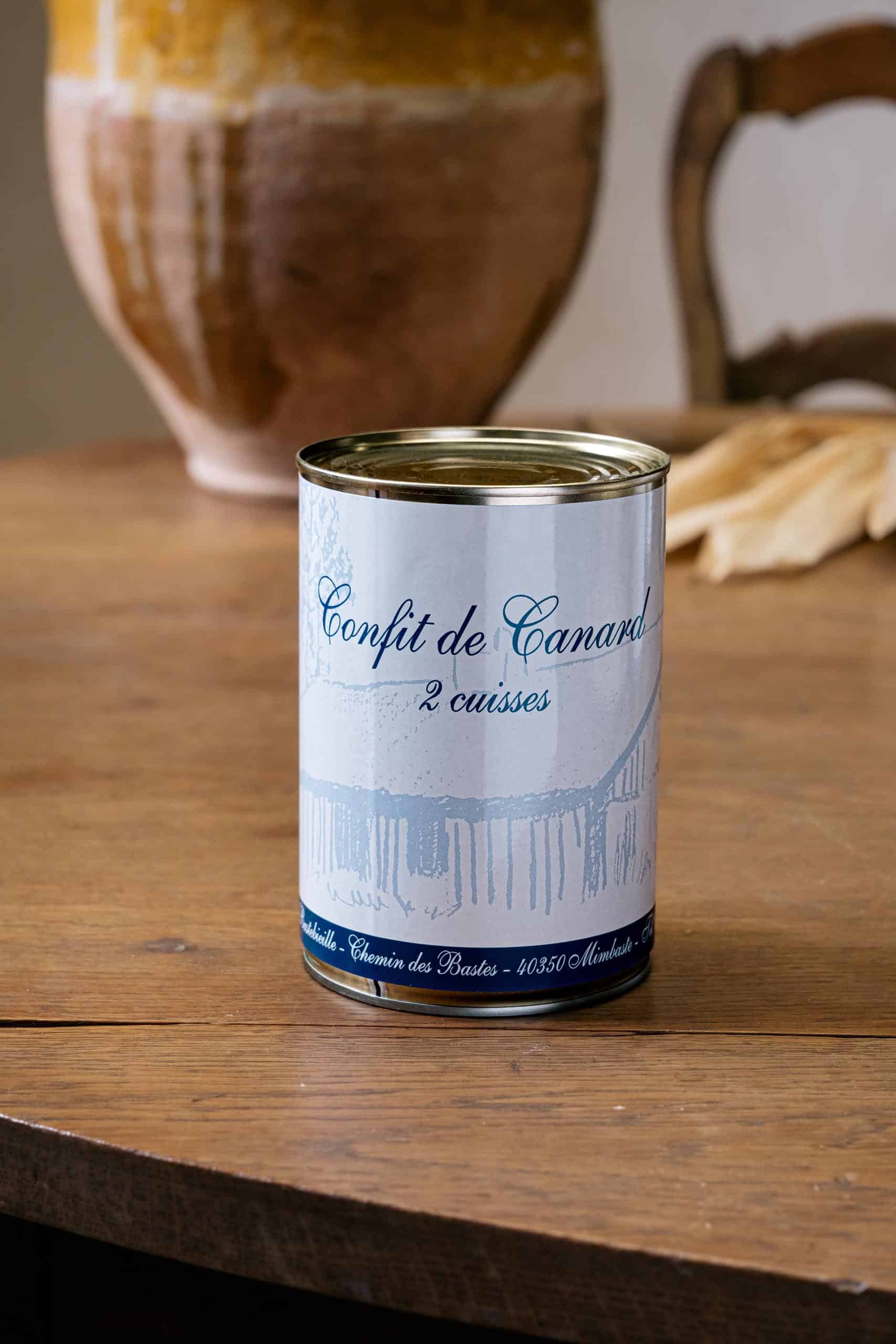 Boîte de confit de canard deux cuisses, étiquette bleue et blanche, table de bois