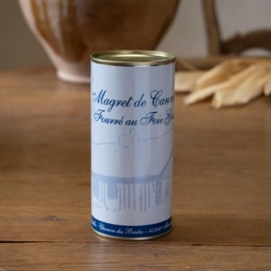 Haute boîte cylindrique de magret fourré au foie gras sur une table patinée